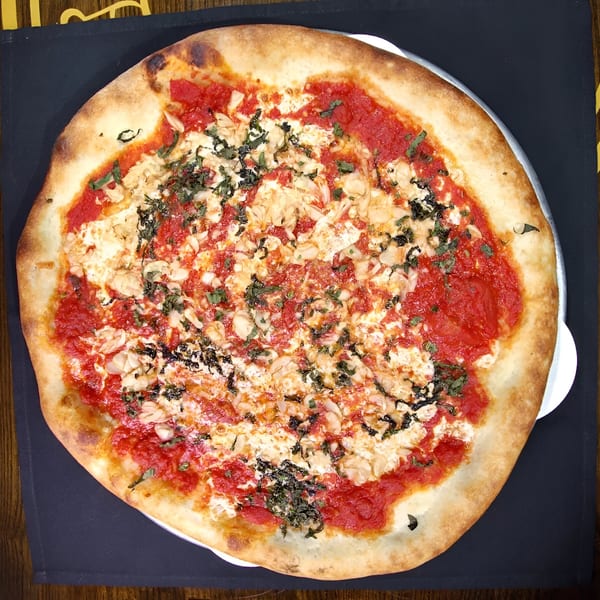 A Biaggio Pizzeria & Family Restaurant pizza with red sauce, white cheese, and basil.