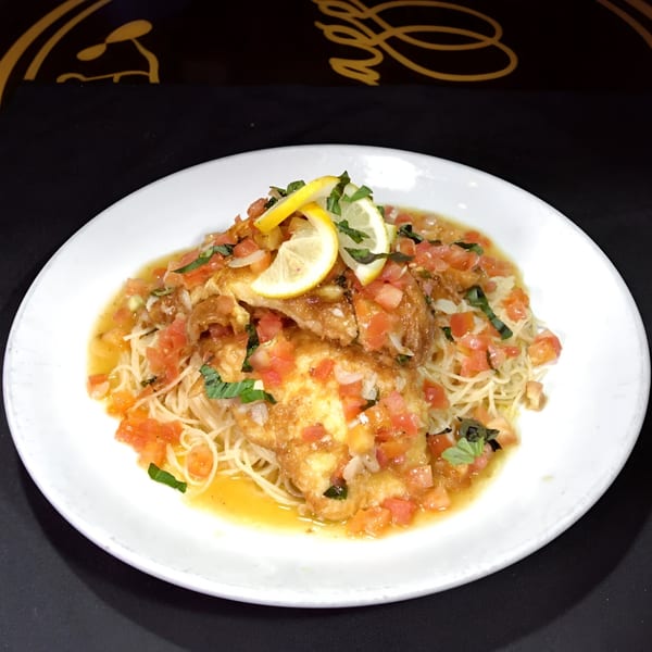 Biaggio Pizzeria's chicken piccata with angel hair pasta, diced tomatoes, basil, and lemon slices.